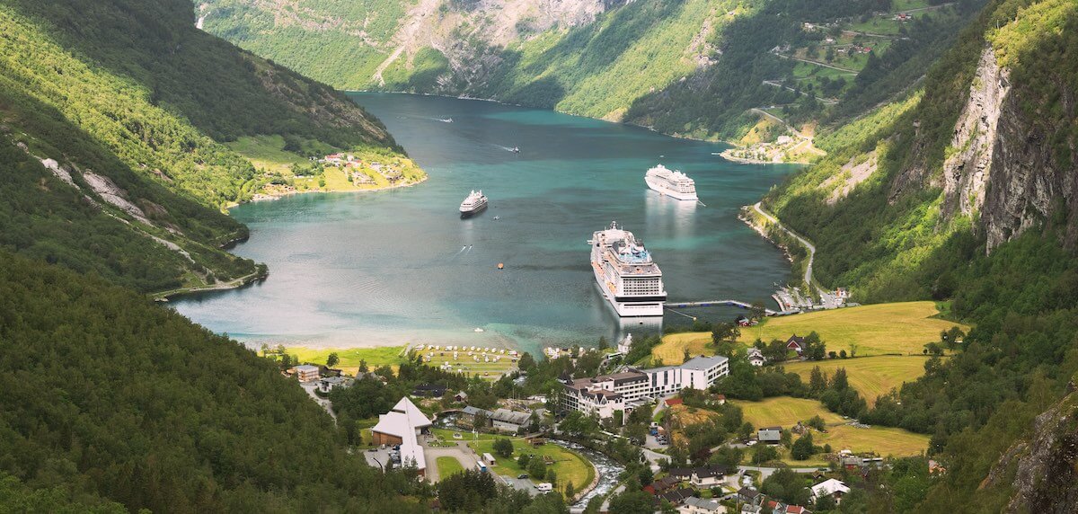 Geirangerfjord, Norway. Aerial View Of Geiranger In Geirangerfjorden In Summer Day. Touristic Ship Ferry Boat Liner Moored Near Geiranger. Famous Norwegian Landmark And Popular Destination.